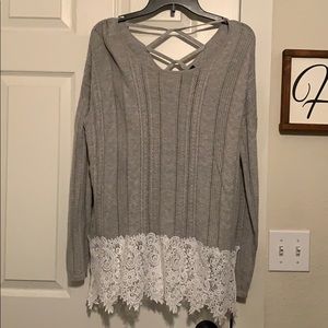 Grey sweater with white lace along the bottom.